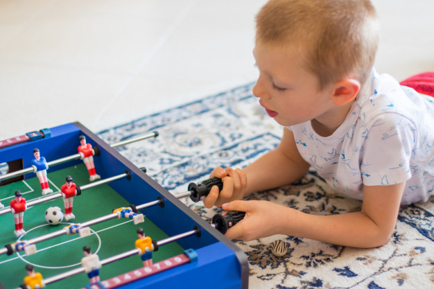 niño jugando futbolín